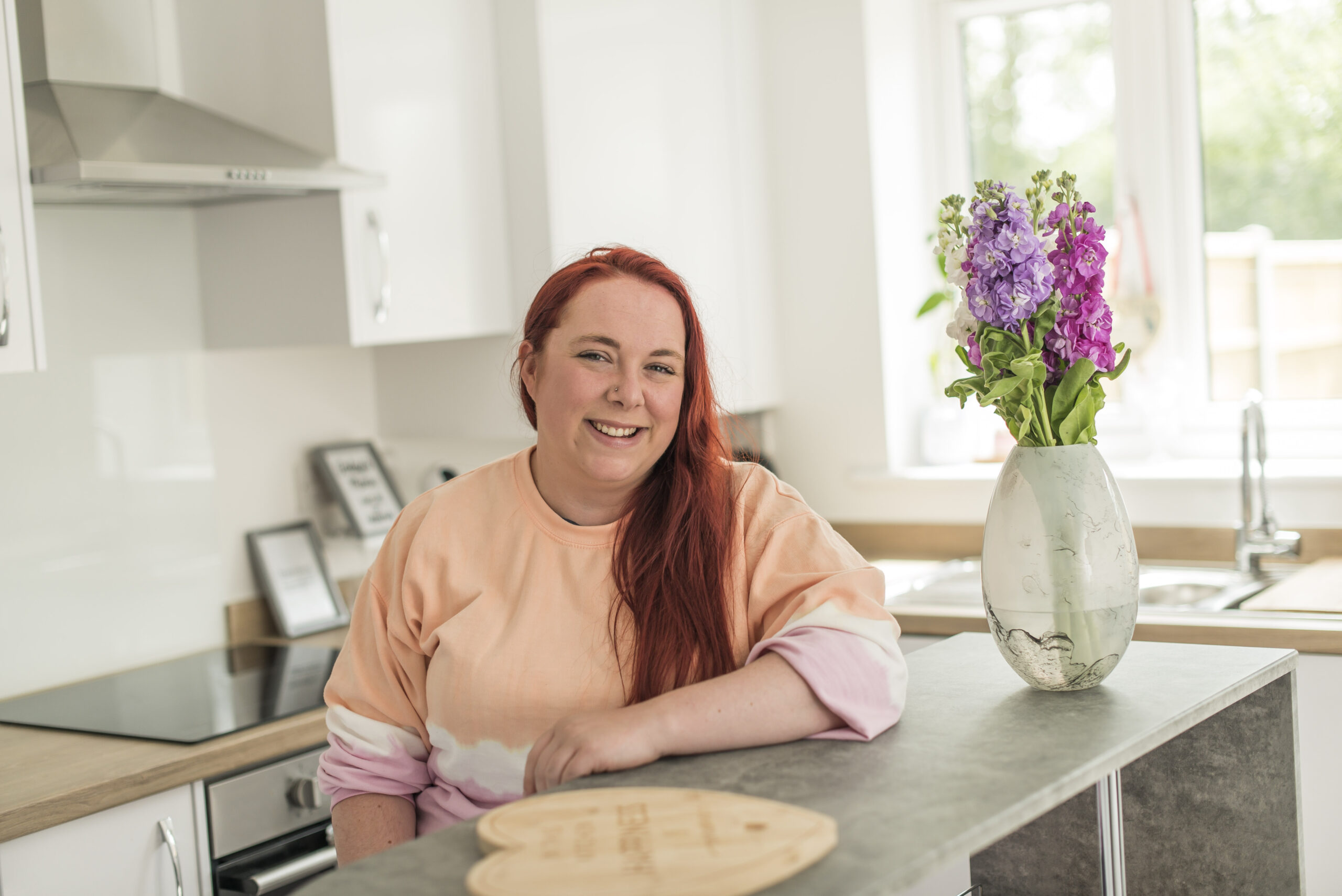 Zoe in her kitchen beside a vase of flowers