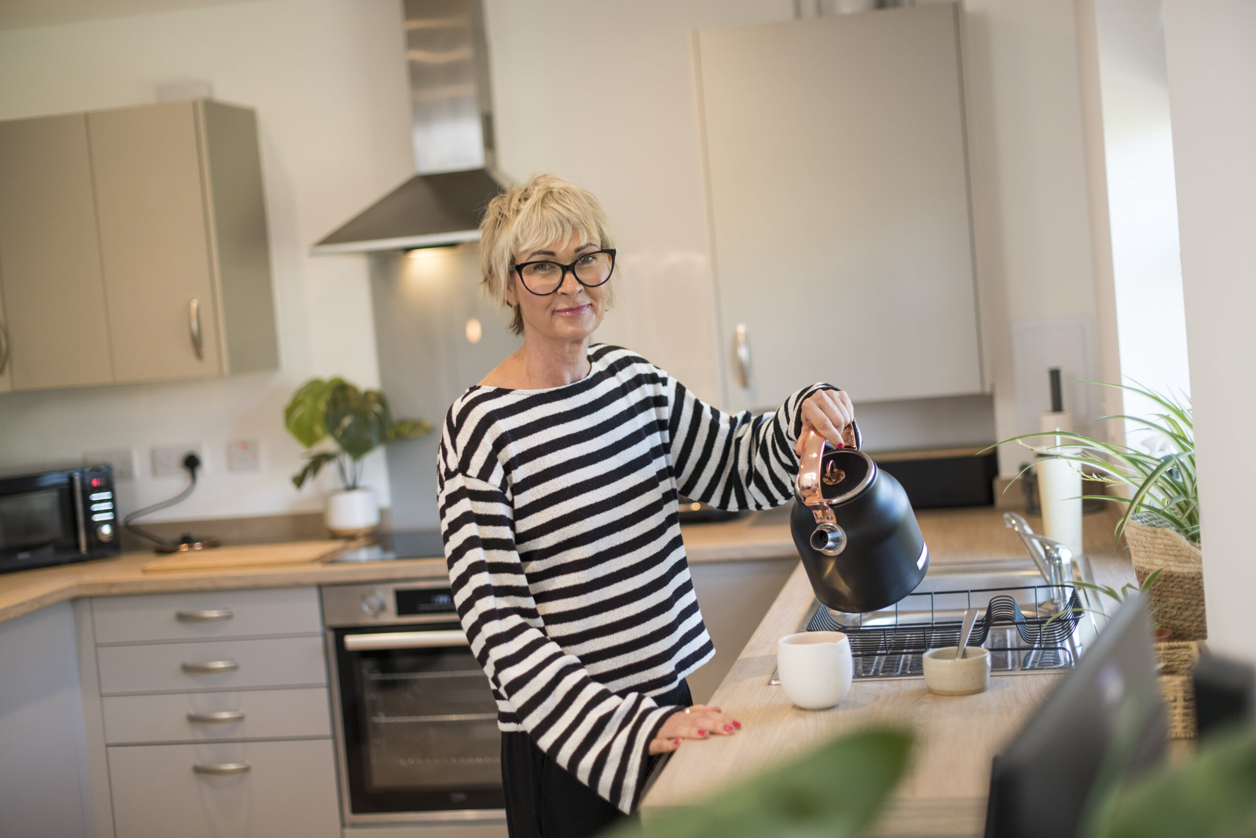 Kelly pouring a kettle in her kitchen