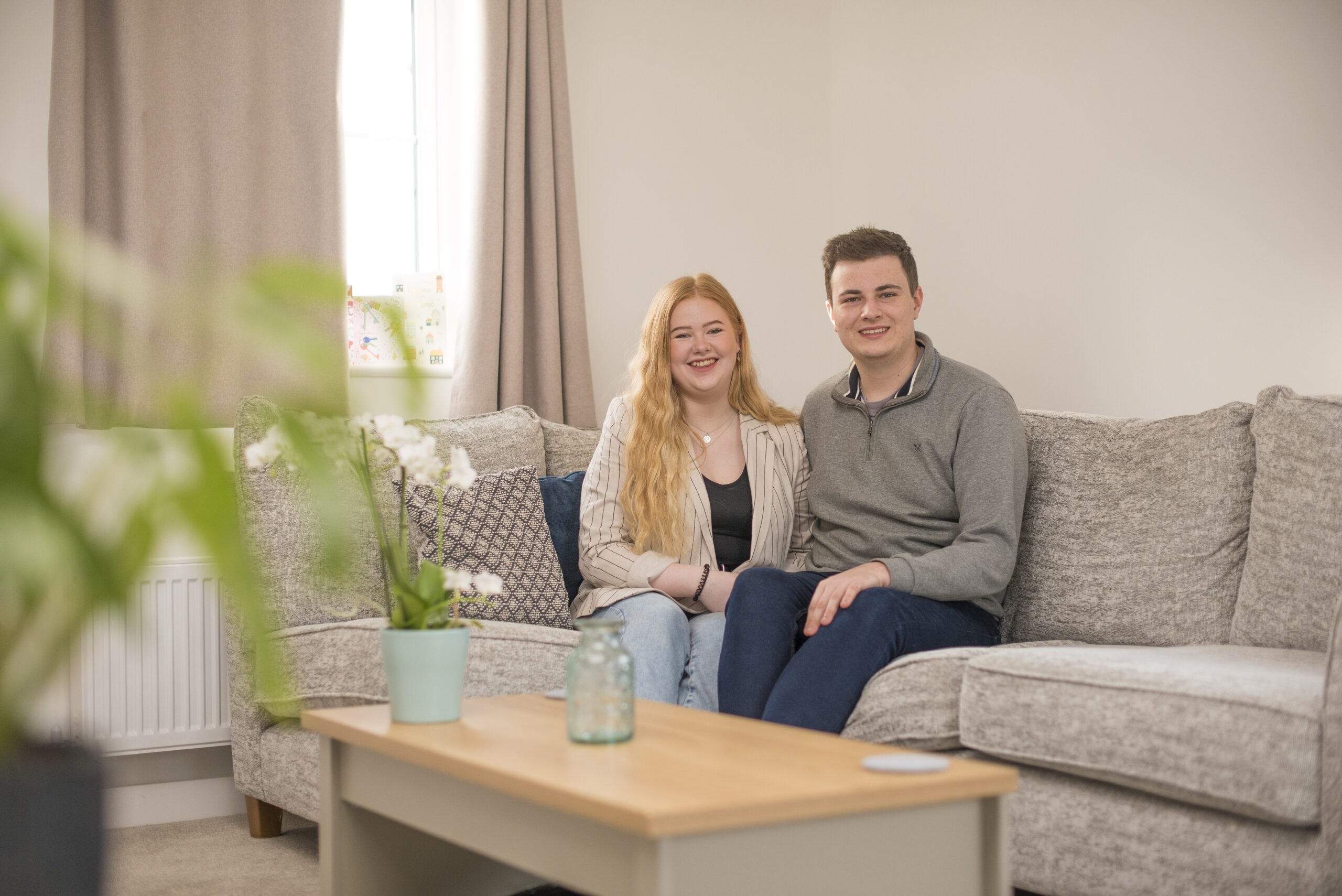 Sam and Emma sitting on their sofa