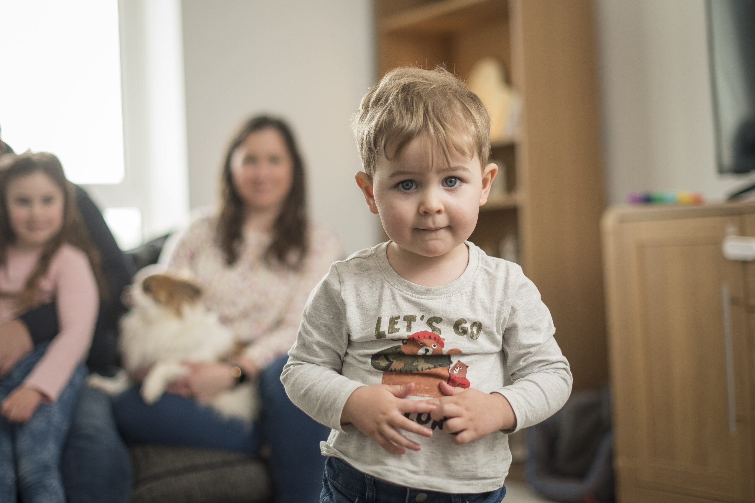 The couple's son holding a toy in the living room