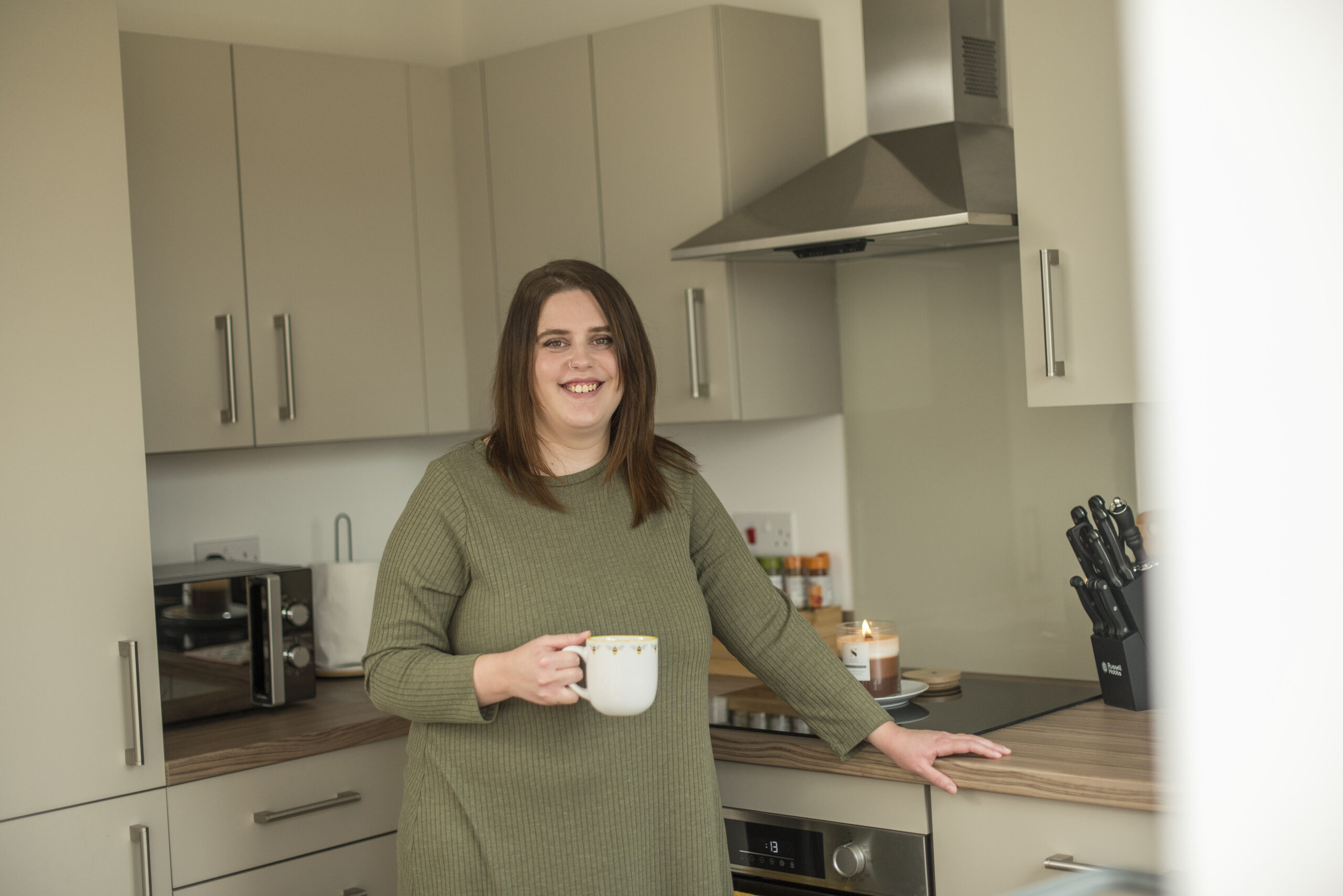 Chloe holding a mug in her kitchen