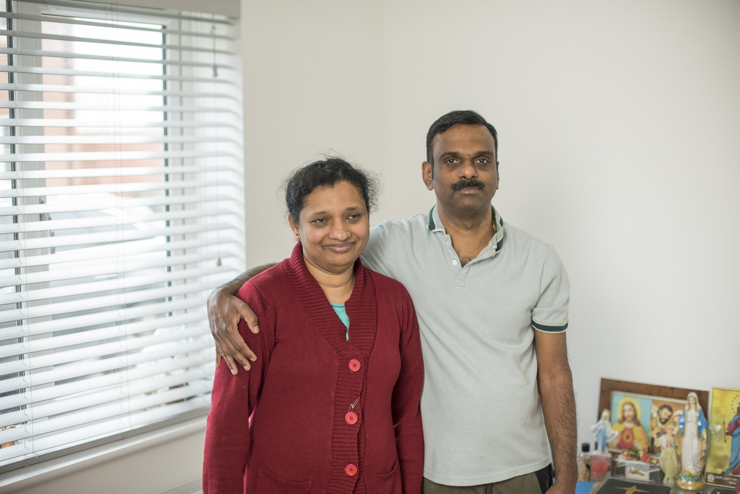 Siby and Merin standing by a window in their home
