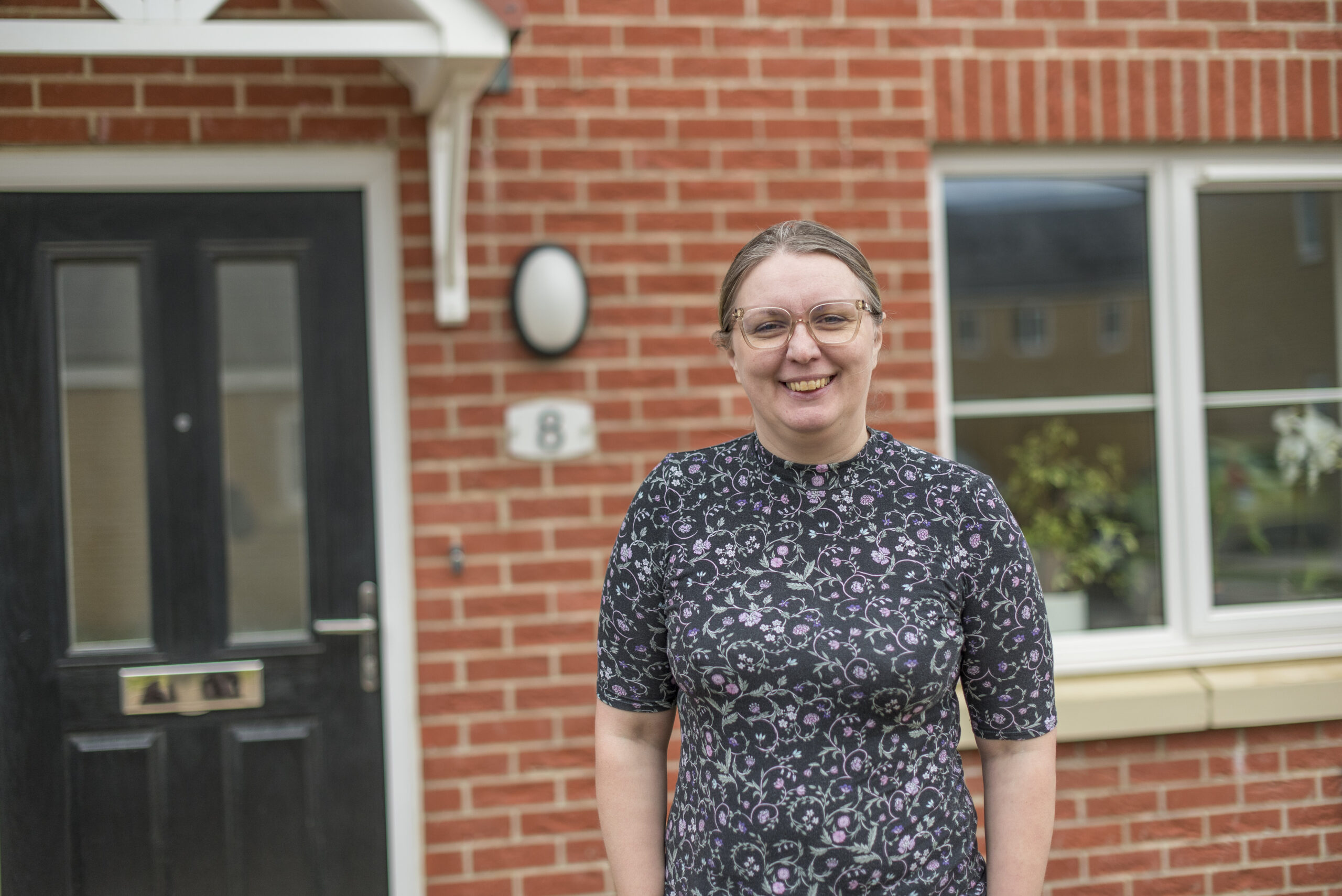 Katarzyna smiling by her front door