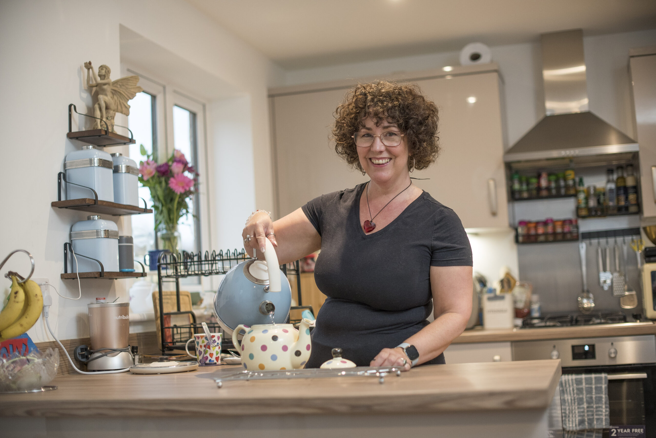 Lisa pouring tea from a teapot in her kitchen